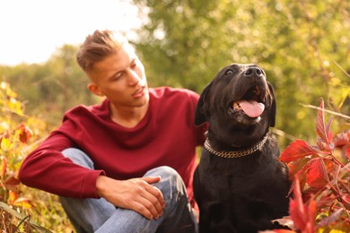 Photo of Man with cute dog outdoors on autumn day, selective focus