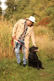 Smiling man with cute dog outdoors on autumn day