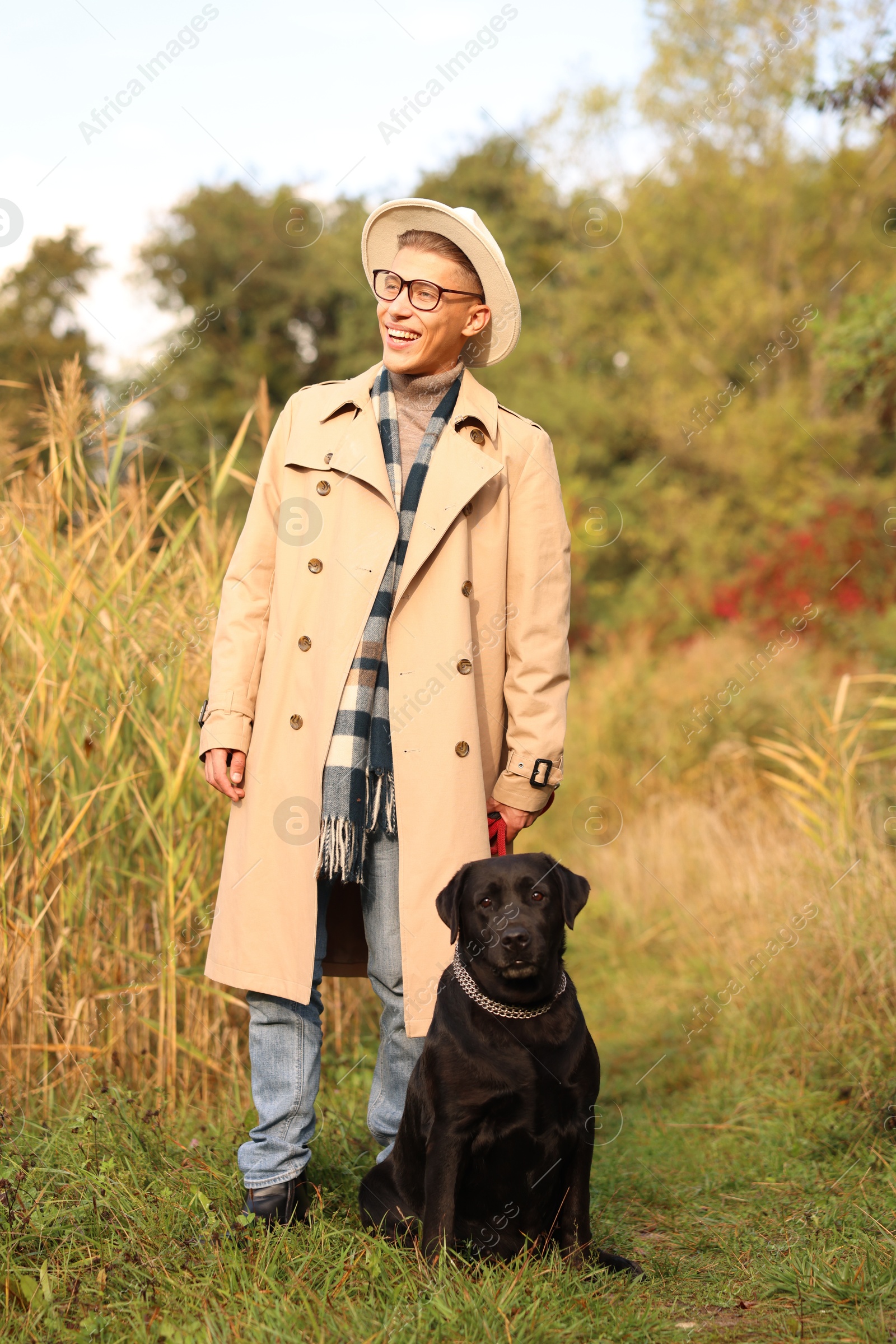 Photo of Smiling man with cute dog outdoors on autumn day