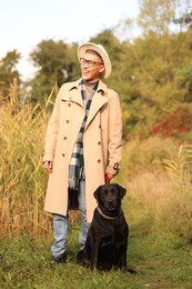 Smiling man with cute dog outdoors on autumn day