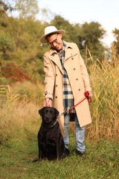 Photo of Smiling man with cute dog outdoors on autumn day