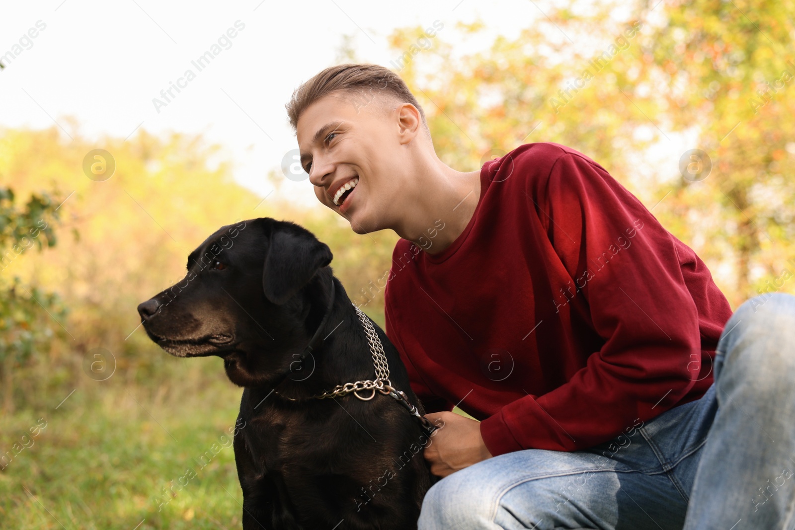 Photo of Smiling man with cute dog outdoors on autumn day