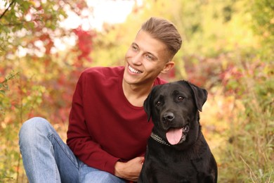 Smiling man with cute dog outdoors on autumn day