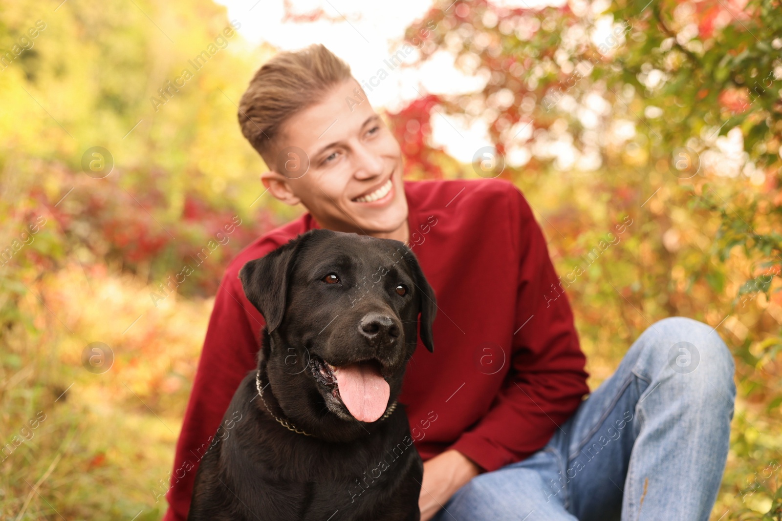 Photo of Smiling man with cute dog outdoors on autumn day