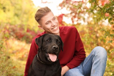 Smiling man with cute dog outdoors on autumn day