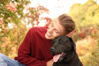 Photo of Smiling man with cute dog outdoors on autumn day