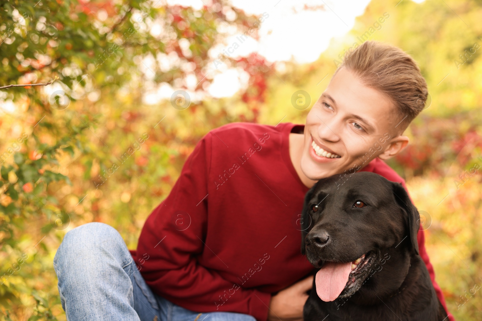 Photo of Smiling man with cute dog outdoors on autumn day