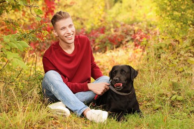 Photo of Smiling man with cute dog outdoors on autumn day