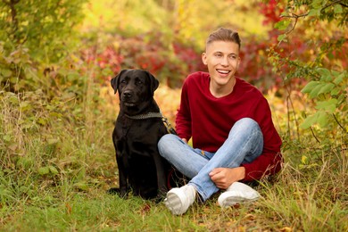 Smiling man with cute dog outdoors on autumn day