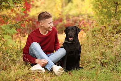 Photo of Smiling man with cute dog outdoors on autumn day