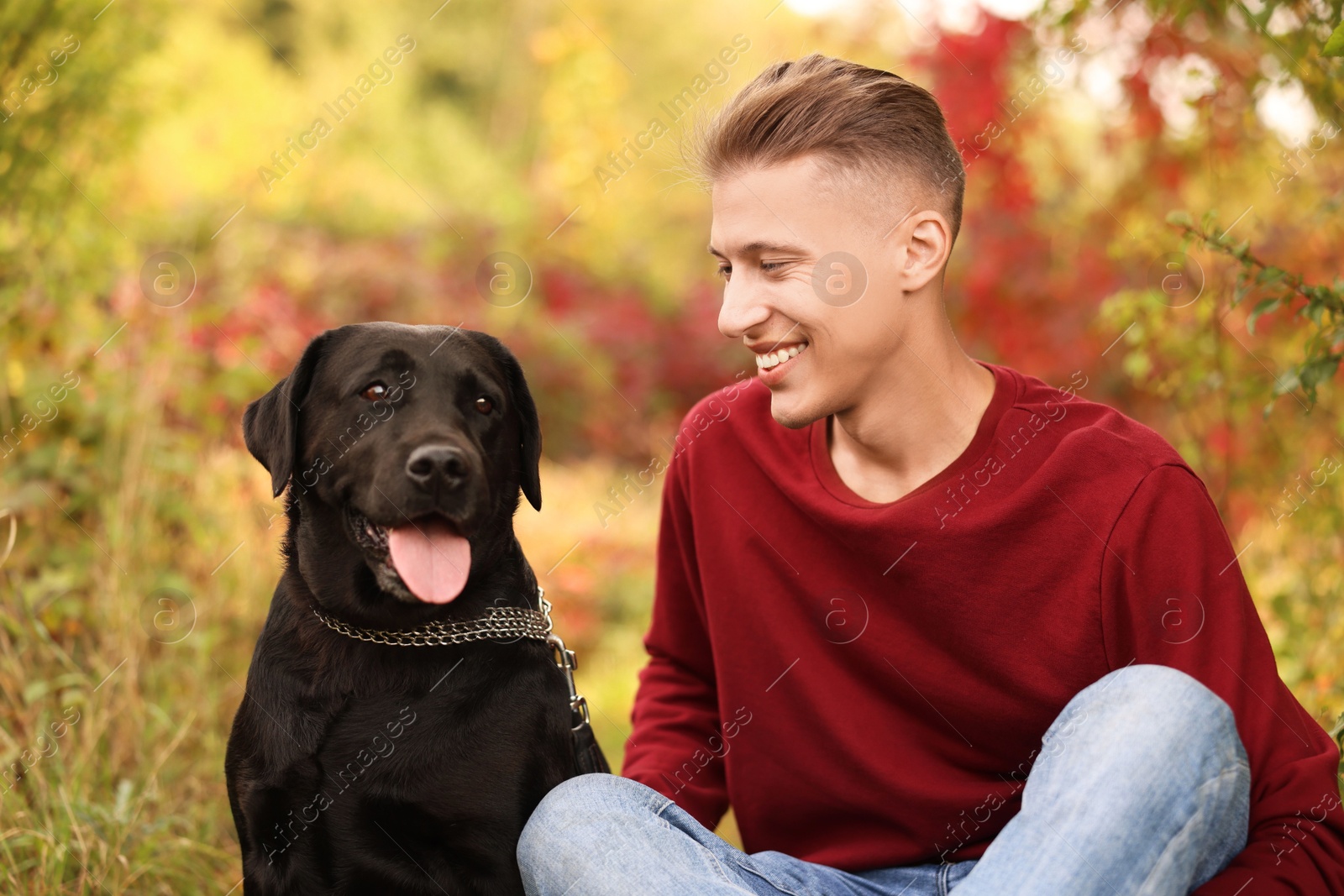 Photo of Smiling man with cute dog outdoors on autumn day