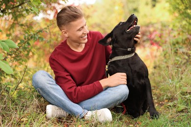 Smiling man with cute dog outdoors on autumn day