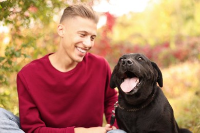 Photo of Smiling man with cute dog outdoors on autumn day