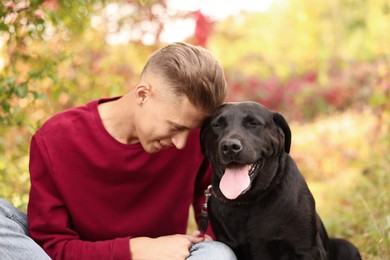 Photo of Smiling man with cute dog outdoors on autumn day