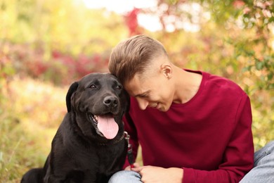 Photo of Smiling man with cute dog outdoors on autumn day