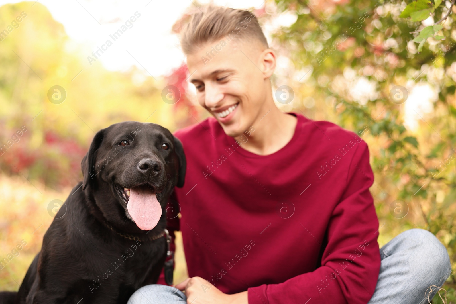 Photo of Smiling man with cute dog outdoors on autumn day