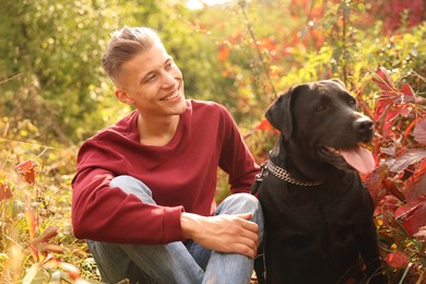 Photo of Smiling man with cute dog outdoors on autumn day