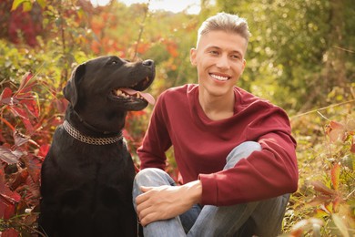 Smiling man with cute dog outdoors on autumn day