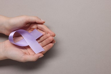 Photo of Woman with violet ribbon on grey background, top view with space for text. Alzheimer disease, epilepsy and pancreas cancer awareness