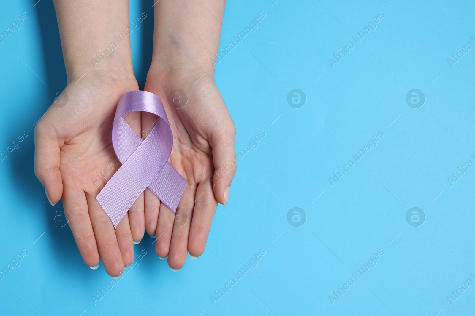 Photo of Woman with violet ribbon on light blue background, top view with space for text. Alzheimer disease, epilepsy and pancreas cancer awareness