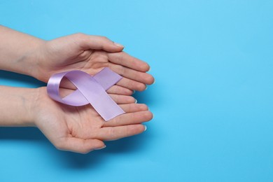 Photo of Woman with violet ribbon on light blue background, top view with space for text. Alzheimer disease, epilepsy and pancreas cancer awareness