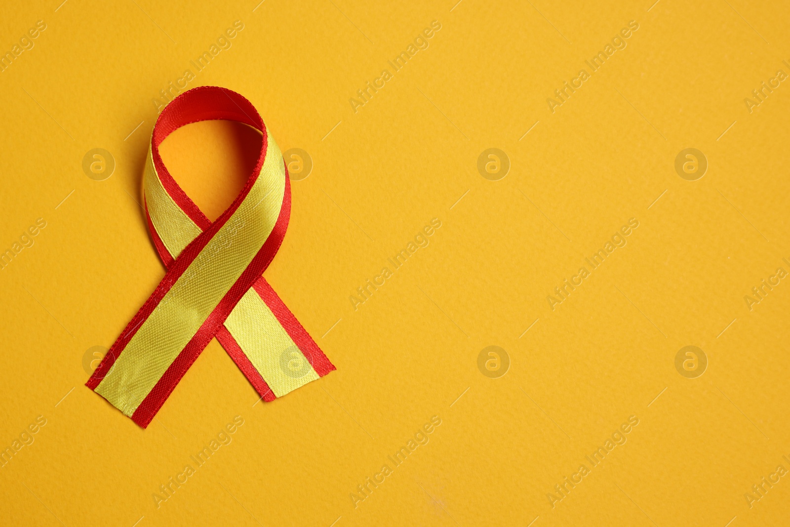 Photo of One colorful ribbon on yellow background, top view with space for text. Hepatitis C awareness