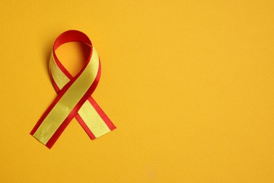 One colorful ribbon on yellow background, top view with space for text. Hepatitis C awareness