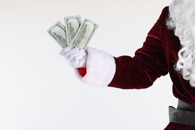 Photo of Santa Claus holding dollar banknotes on white background, closeup