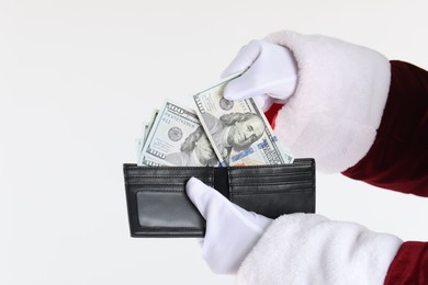 Photo of Santa Claus taking dollar banknotes out of wallet on white background, closeup