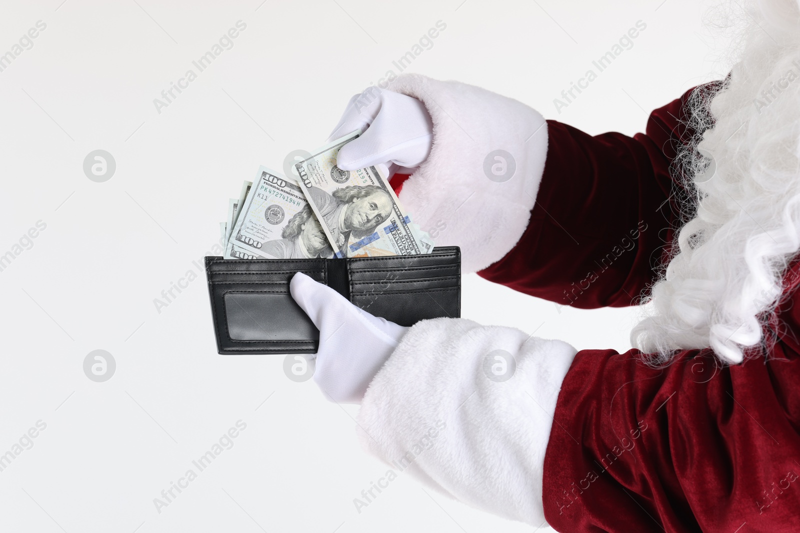 Photo of Santa Claus taking dollar banknotes out of wallet on white background, closeup