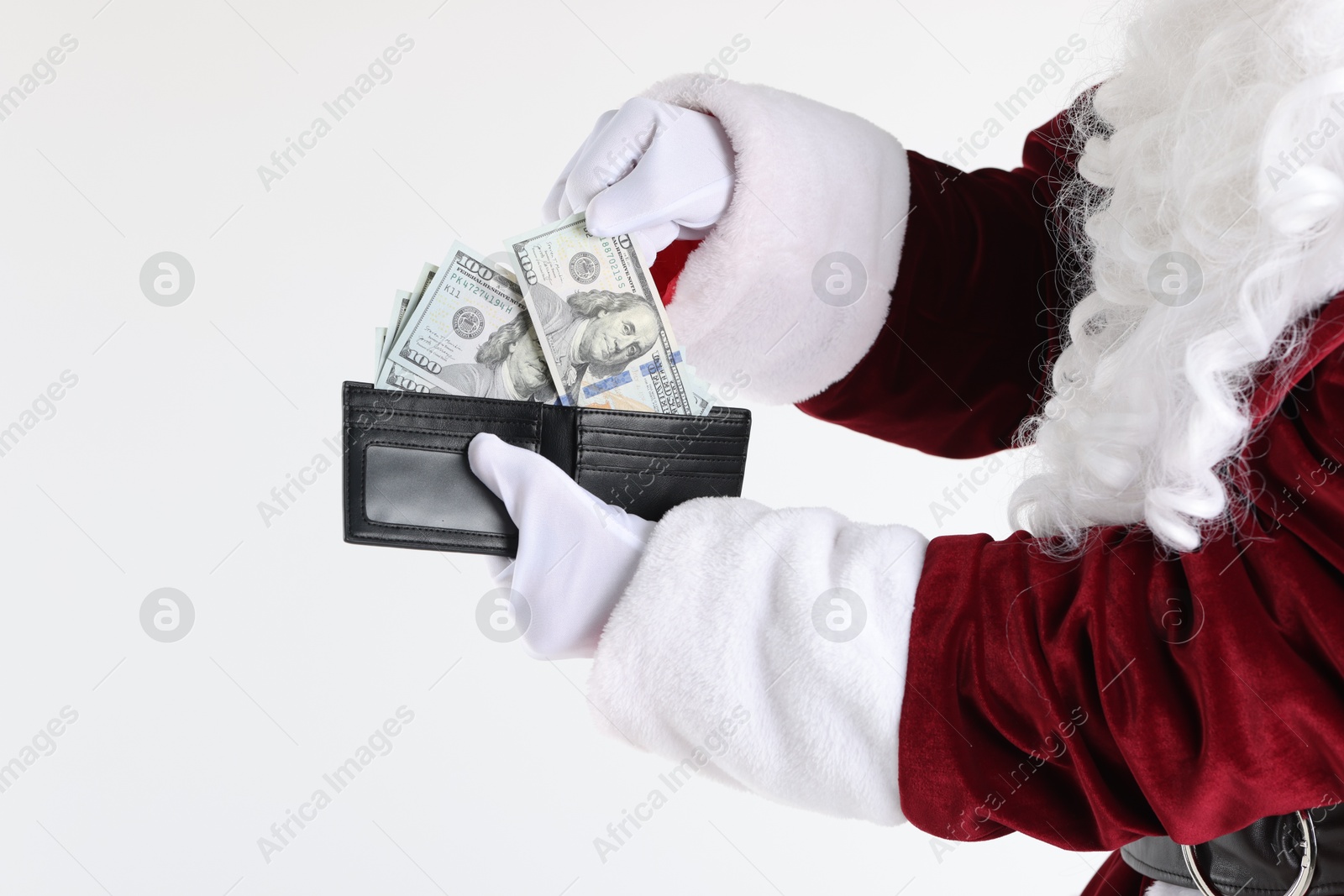 Photo of Santa Claus taking dollar banknotes out of wallet on white background, closeup