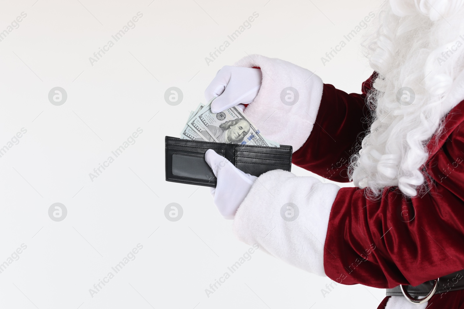 Photo of Santa Claus taking dollar banknotes out of wallet on white background, closeup. Space for text