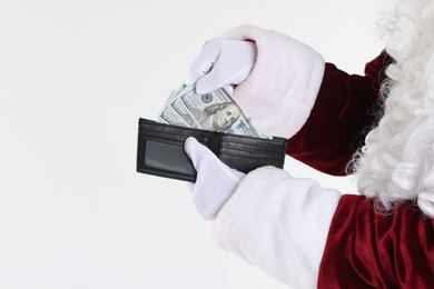 Photo of Santa Claus taking dollar banknotes out of wallet on white background, closeup. Space for text