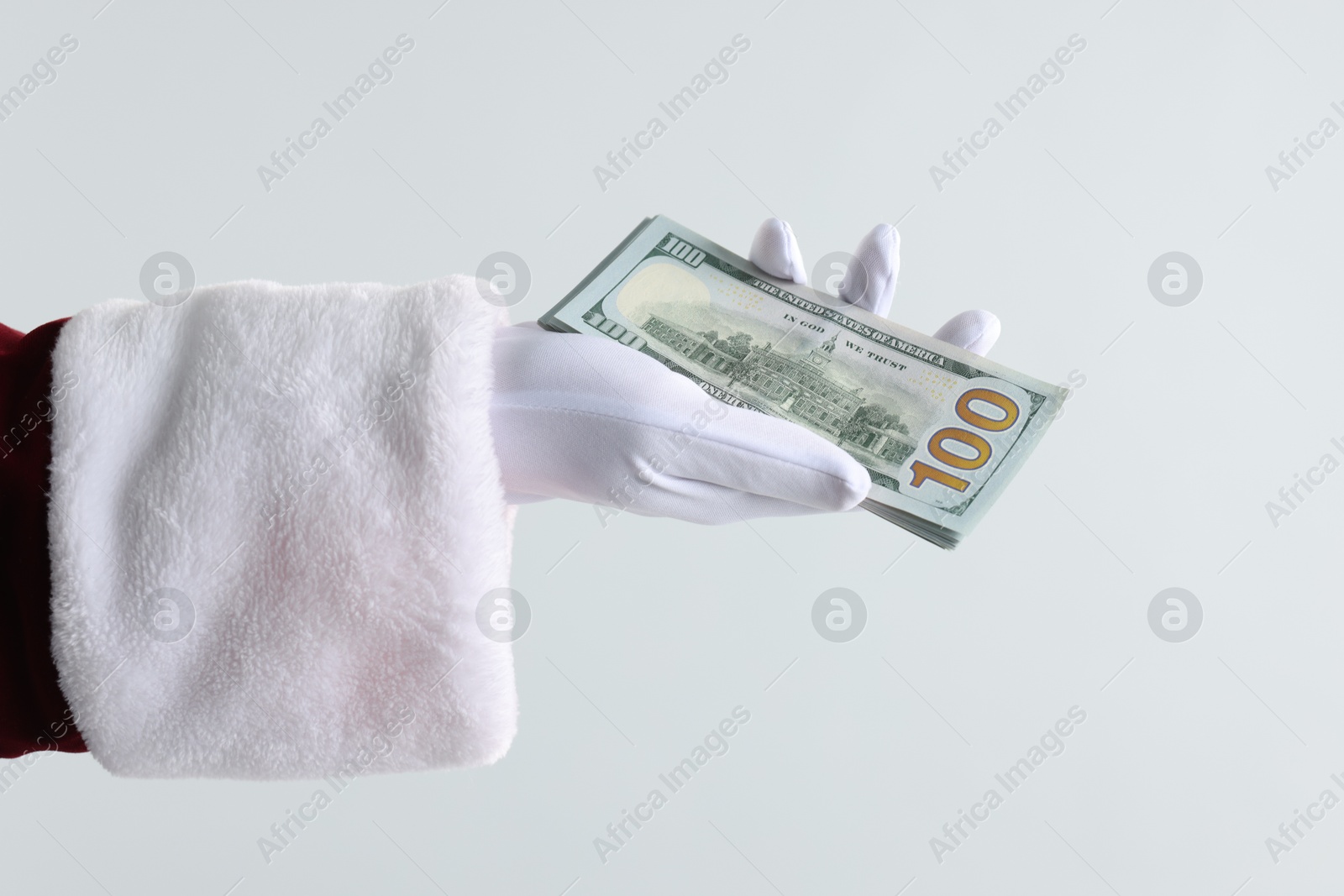 Photo of Santa Claus holding dollar banknotes on gray background, closeup