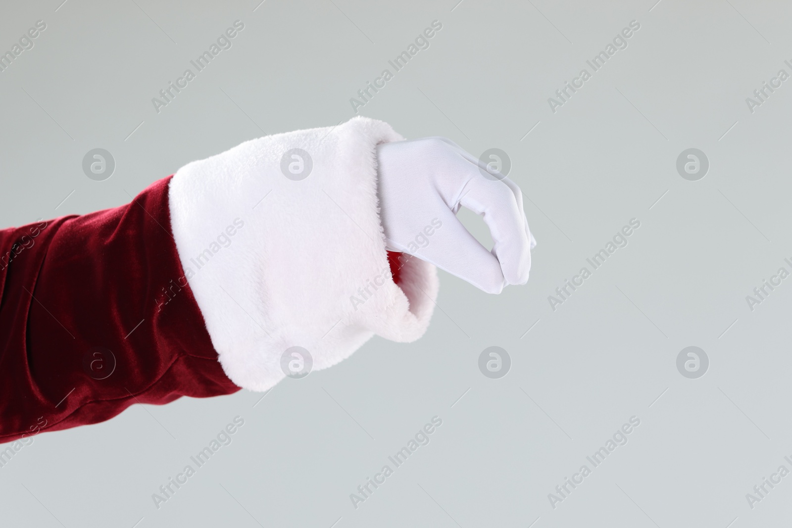 Photo of Santa Claus holding something on gray background, closeup