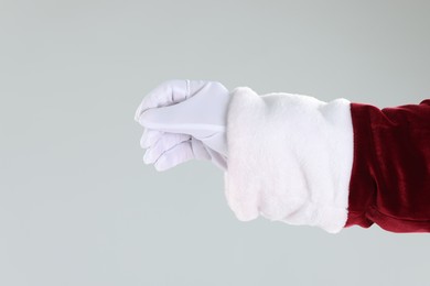 Photo of Santa Claus holding something on gray background, closeup