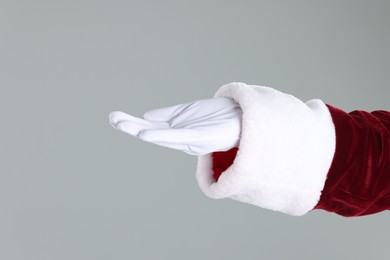 Photo of Santa Claus holding something on gray background, closeup