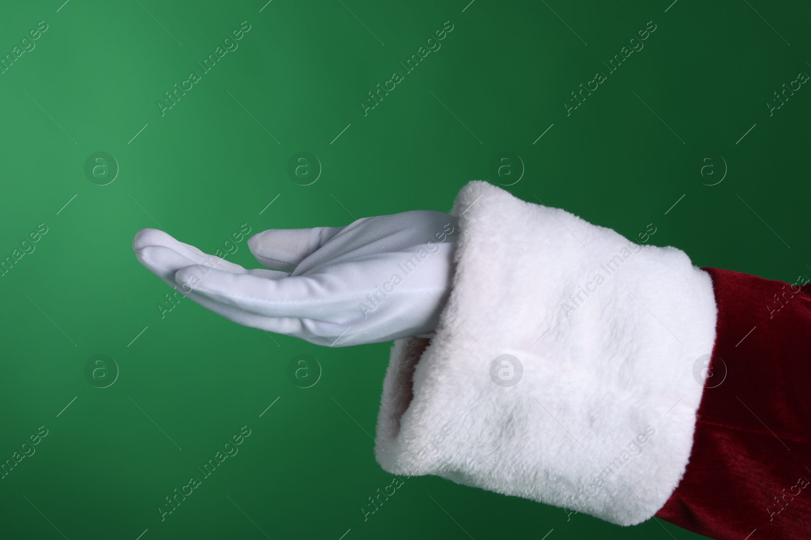 Photo of Santa Claus holding something on green background, closeup