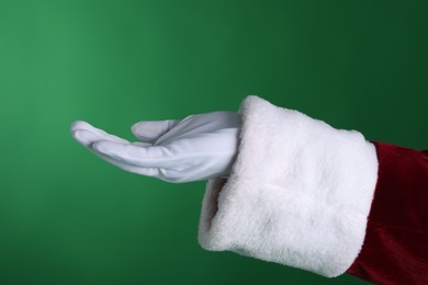 Photo of Santa Claus holding something on green background, closeup