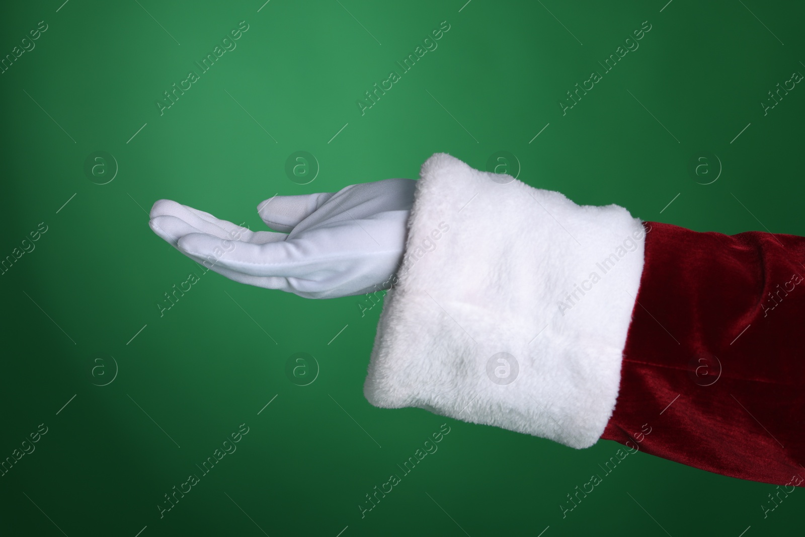 Photo of Santa Claus holding something on green background, closeup