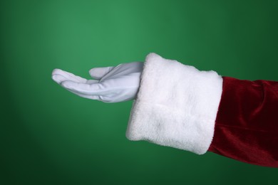 Photo of Santa Claus holding something on green background, closeup