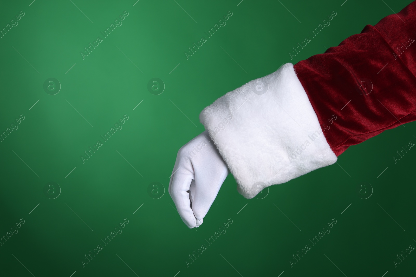 Photo of Santa Claus holding something on green background, closeup. Space for text