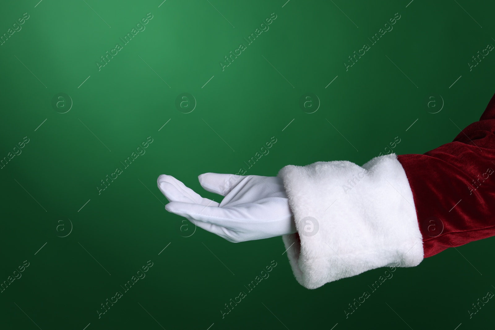 Photo of Santa Claus holding something on green background, closeup