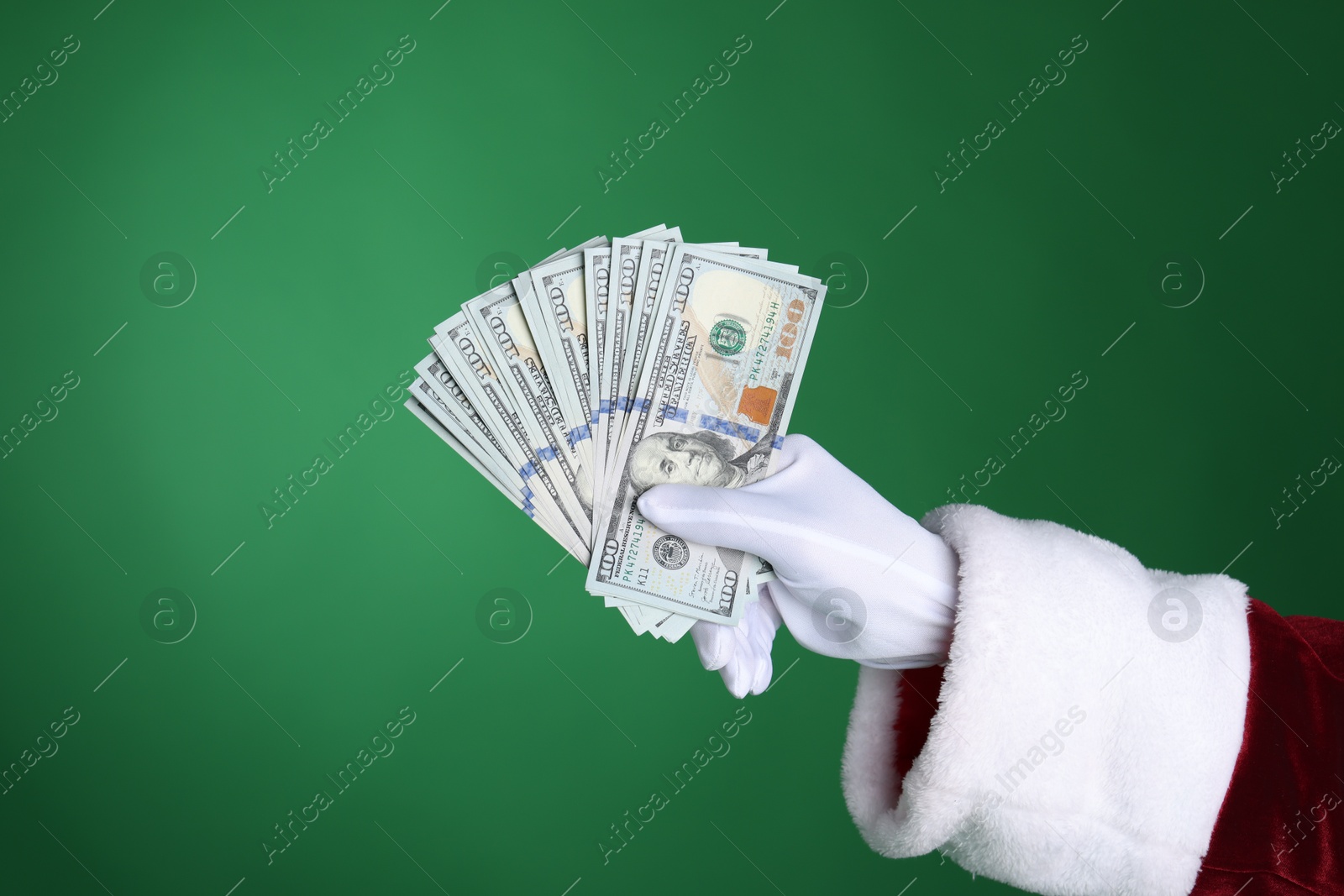 Photo of Santa Claus holding dollar banknotes on green background, closeup. Space for text