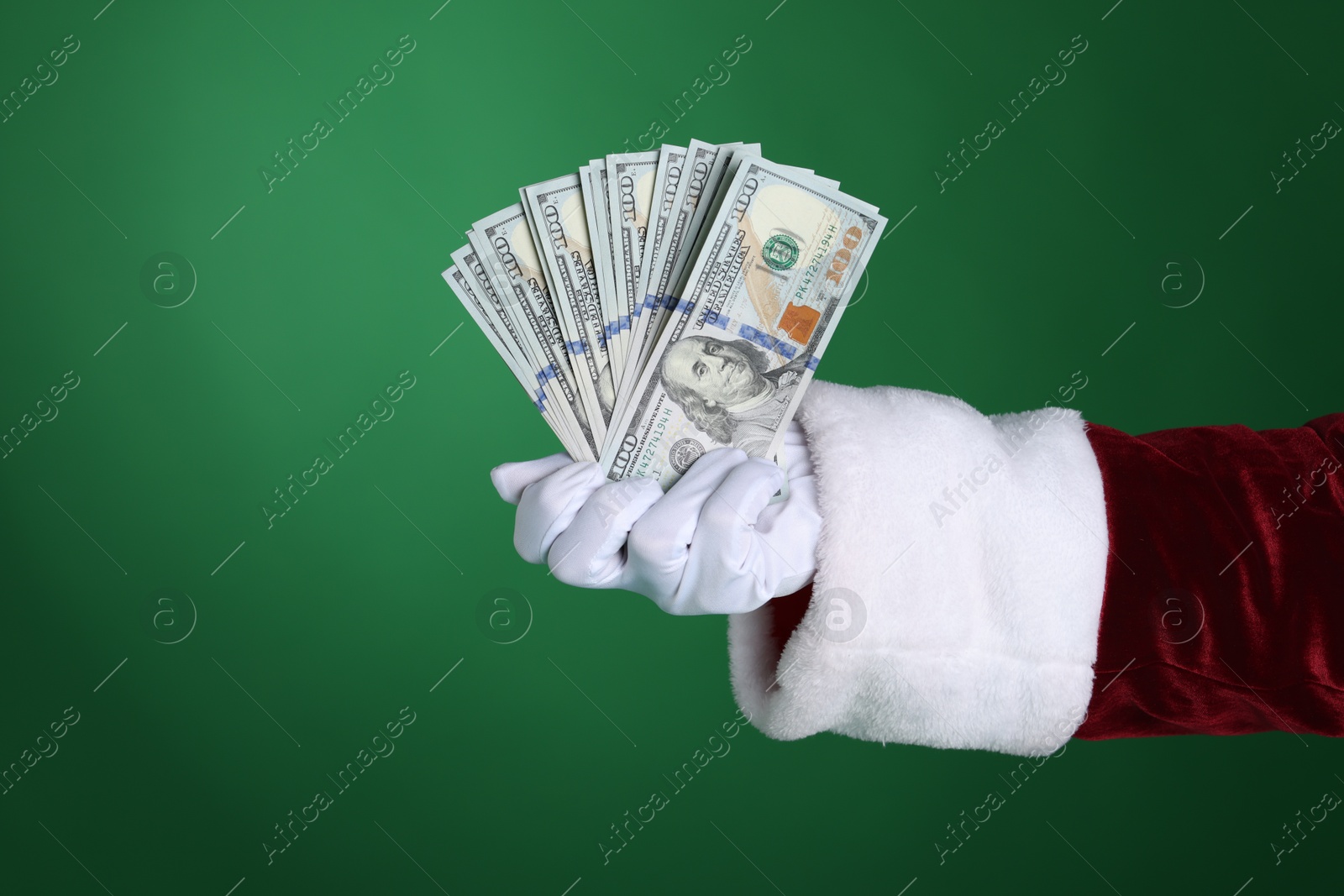 Photo of Santa Claus holding dollar banknotes on green background, closeup. Space for text