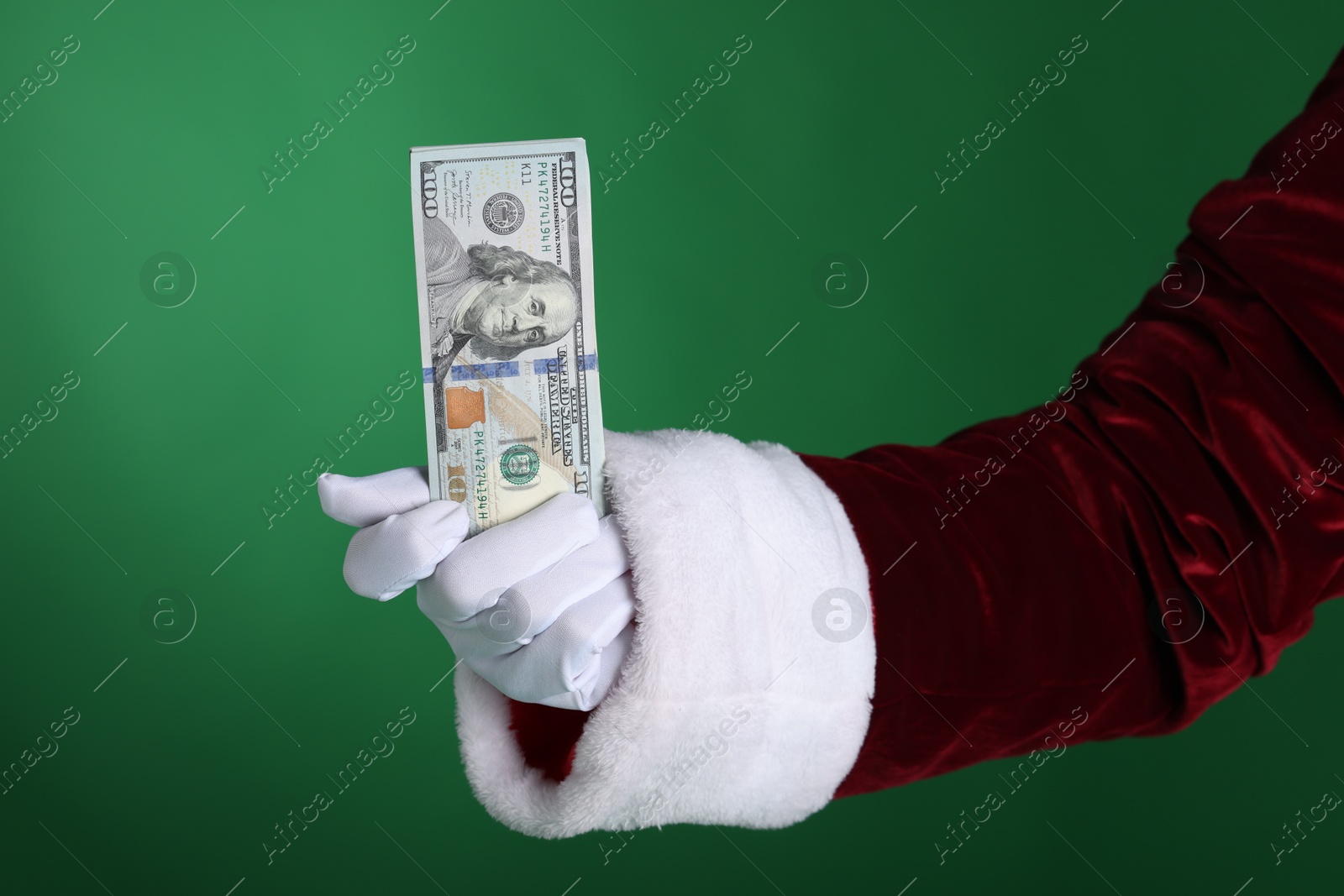 Photo of Santa Claus holding dollar banknotes on green background, closeup