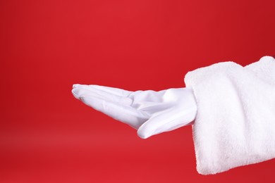 Photo of Santa Claus holding something on red background, closeup