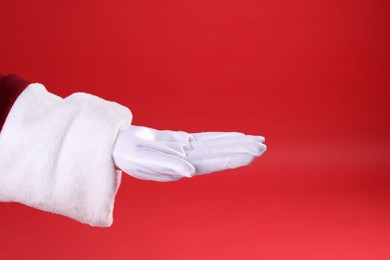 Photo of Santa Claus holding something on red background, closeup