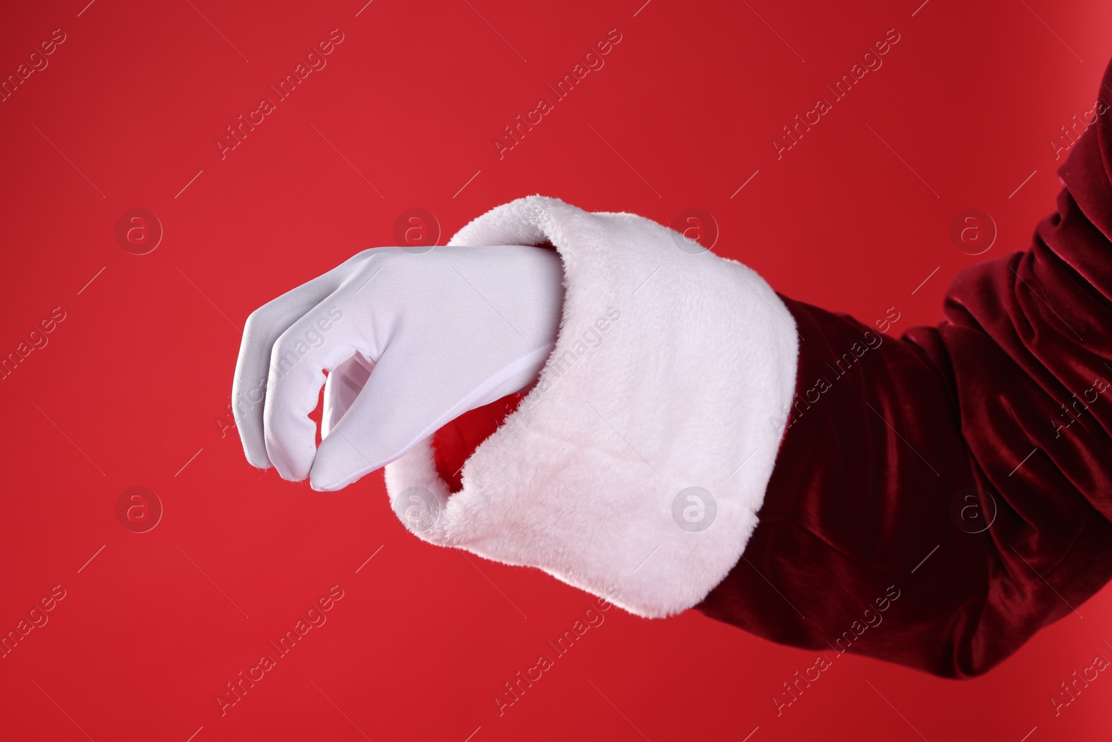 Photo of Santa Claus holding something on red background, closeup