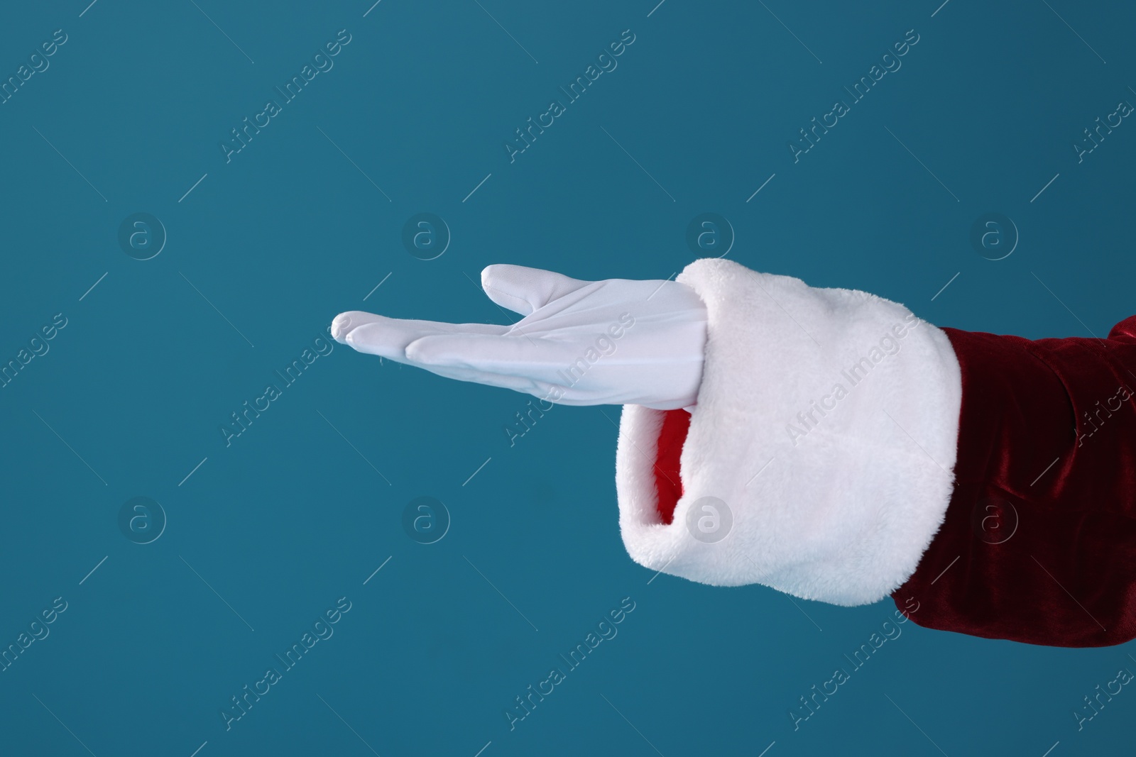 Photo of Santa Claus holding something on blue background, closeup